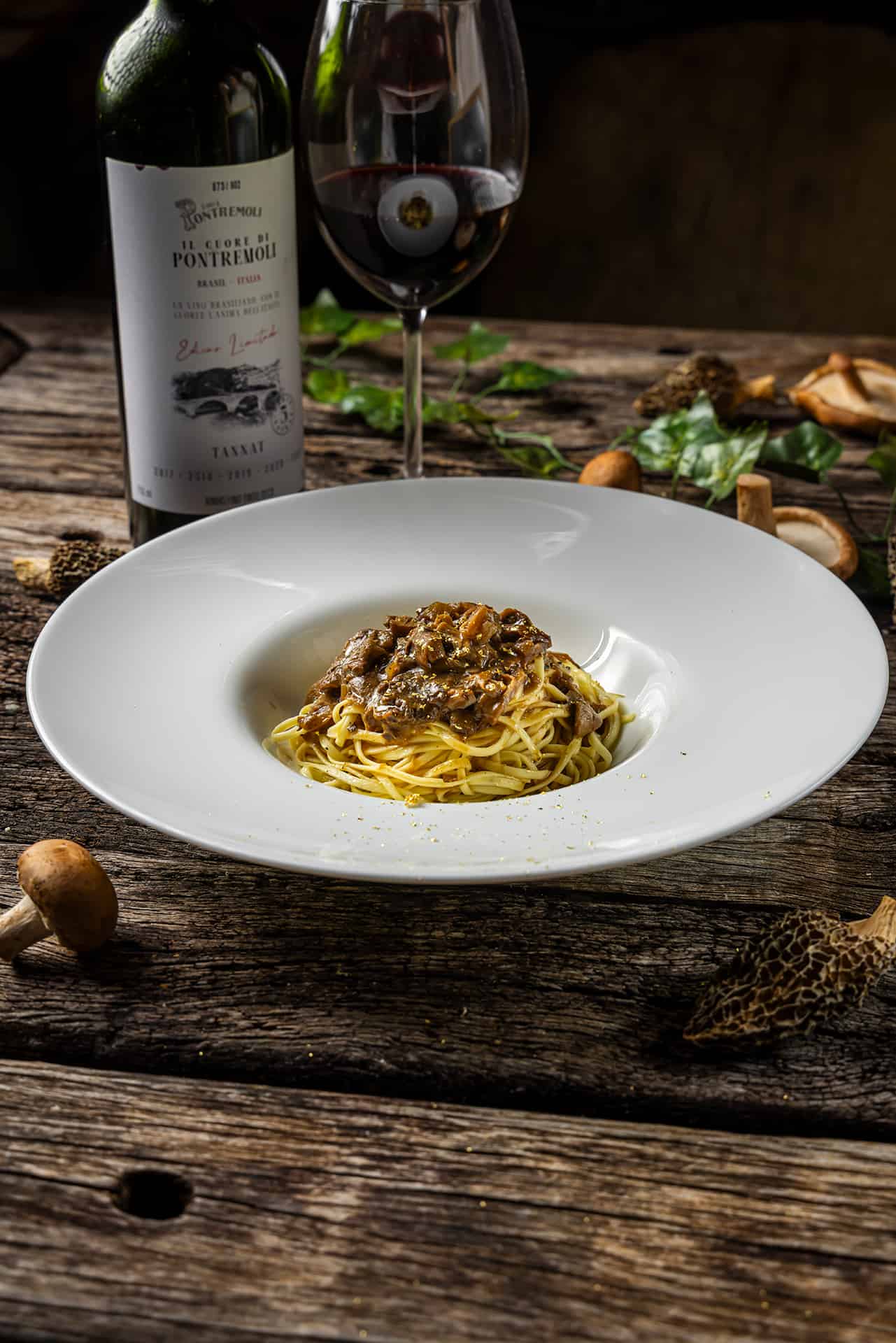 Massa com cogumelos servida com vinho tinto